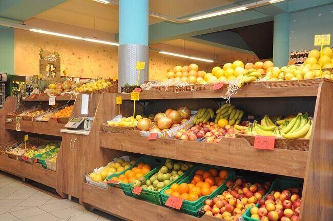 drewniane regały z owocami i warzywami w sklepie spożywczym